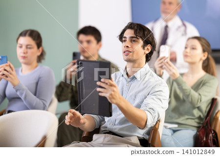 Students snuck the barcode during the lecture against the background of the doctor Students snuck the barcode during the lecture against the background of the doctor 141012849