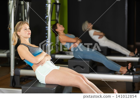 Woman doing bends on a reformer Woman doing bends on a reformer 141012854