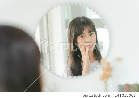 A girl who is concerned about the condition of her skin A girl who is concerned about the condition of her skin 141013062