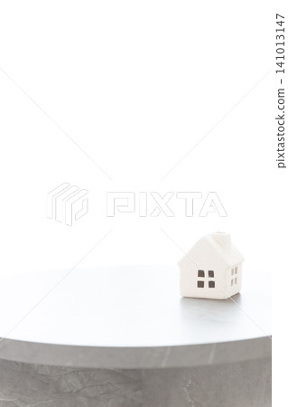 A small white house on a table, with white space (copy space) that can be used for real estate and housing-related concepts. A small white house on a table, with white space (copy space) that can be used for real estate and housing-related concepts. 141013147