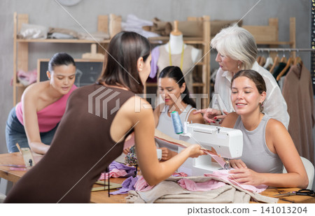 Two women discussing pattern at sewing master class 141013204