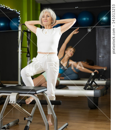 Woman doing exercises on Pilates chair Woman doing exercises on Pilates chair 141013253