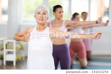 Elderly woman exercising with pilates loop Elderly woman exercising with pilates loop 141013254