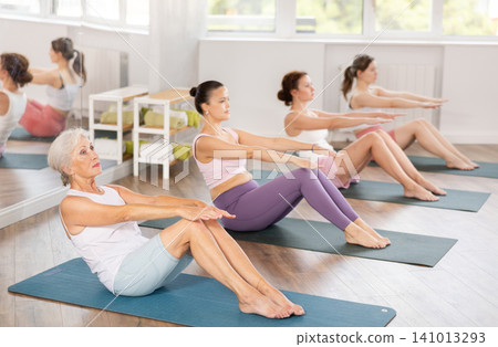 Elderly woman doing pilates in group Elderly woman doing pilates in group 141013293
