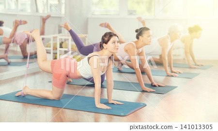 Young woman exercising with pilates loop Young woman exercising with pilates loop 141013305