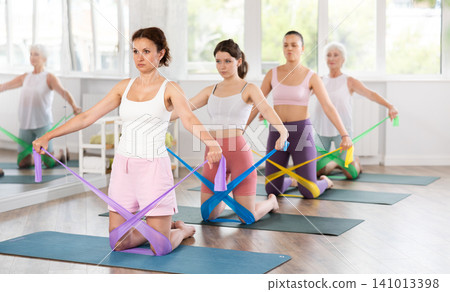 Adult woman exercising with pilates band Adult woman exercising with pilates band 141013398