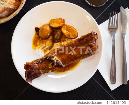 Fried pork ribs served with potatoes on plate Fried pork ribs served with potatoes on plate 141013403