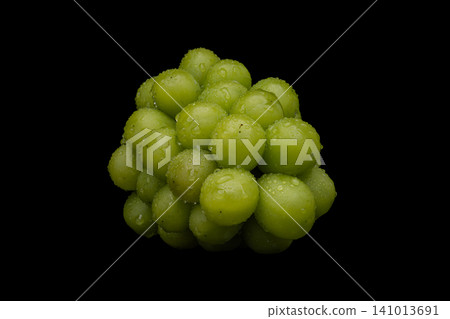 A photograph of wet Shine Muscat grapes against a black background. A photograph of wet Shine Muscat grapes against a black background. 141013691