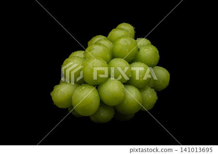 A photograph of wet Shine Muscat grapes against a black background. A photograph of wet Shine Muscat grapes against a black background. 141013695