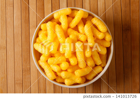 Top view of golden corn sticks in a bowl on a bamboo surface Top view of golden corn sticks in a bowl on a bamboo surface 141013726