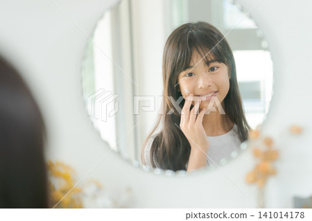 Elementary school girl doing skincare Elementary school girl doing skincare 141014178
