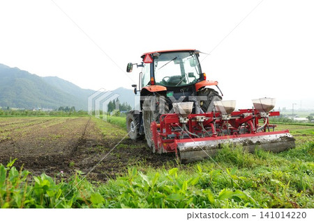 Plowing the field with a tractor Plowing the field with a tractor 141014220