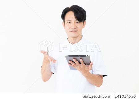 一位身穿白大褂的中年男性針灸師/整骨師，手裡拿著藥片。 141014550