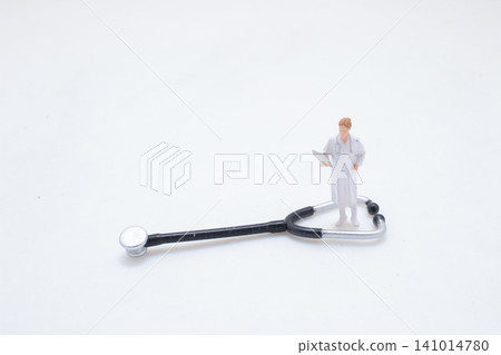 Miniature Doctor Figure Standing On Stethoscope Tool Miniature Doctor Figure Standing On Stethoscope Tool 141014780