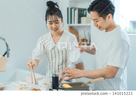 一對夫婦在廚房裡愉快地準備午餐,臉上洋溢著幸福的笑容。 一對夫婦在廚房裡愉快地準備午餐,臉上洋溢著幸福的笑容。 141015221