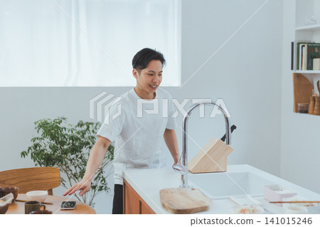 A man eating at the dining table rushes to the kitchen. 141015246