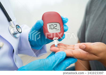 Doctor check diabetes from finger blood sugar level with finger lancet. Doctor check diabetes from finger blood sugar level with finger lancet. 141015397