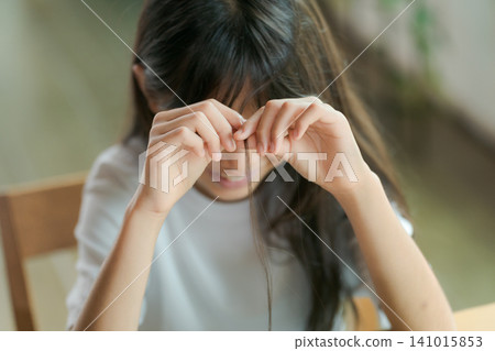A girl playing with her hair A girl playing with her hair 141015853