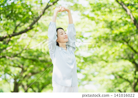Young woman stretching under a tree Lifestyle image 141016022