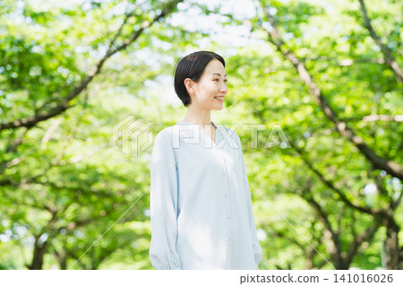 A young woman looking up at the tree-lined street Lifestyle image 141016026