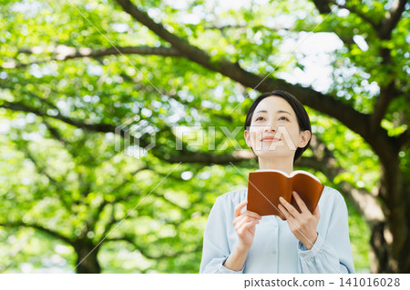 Young woman reading outdoors Lifestyle image Young woman reading outdoors Lifestyle image 141016028