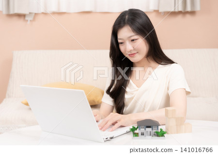 Young women using laptops to consider mortgages and home purchases. Young women using laptops to consider mortgages and home purchases. 141016766