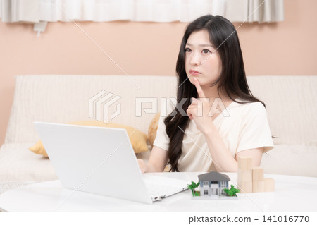 Young women using laptops to consider mortgages and home purchases. Young women using laptops to consider mortgages and home purchases. 141016770