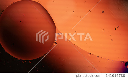Close up of a large orange oil droplet suspended in amber liquid with smaller bubbles, featuring a warm gradient and soft reflections Close up of a large orange oil droplet suspended in amber liquid with smaller bubbles, featuring a warm gradient and soft reflections 141016788