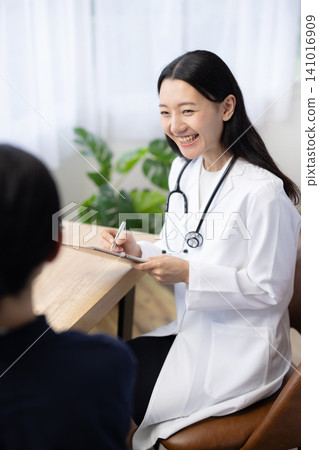 A young Japanese female doctor examining a patient A young Japanese female doctor examining a patient 141016909