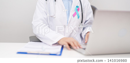 doctor using laptop and report notes on notebook. blue and pink ribbon concept of October male Breast Cancer Awareness month, National Cancer Survivors Month and Pink October Healthcare doctor using laptop and report notes on notebook. blue and pink ribbon concept of October male Breast Cancer Awareness month, National Cancer Survivors Month and Pink October Healthcare 141016980