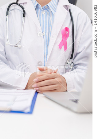 Professional doctor wearing lab coat using laptop and taking report notes on notebook for Breast Cancer Awareness month, World Cancer Day, National Cancer Survivors Month and Pink October in hospital Professional doctor wearing lab coat using laptop and taking report notes on notebook for Breast Cancer Awareness month, World Cancer Day, National Cancer Survivors Month and Pink October in hospital 141016982
