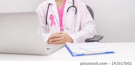 Professional doctor wearing lab coat using laptop and taking report notes on notebook for Breast Cancer Awareness month, World Cancer Day, National Cancer Survivors Month and Pink October in hospital Professional doctor wearing lab coat using laptop and taking report notes on notebook for Breast Cancer Awareness month, World Cancer Day, National Cancer Survivors Month and Pink October in hospital 141017002