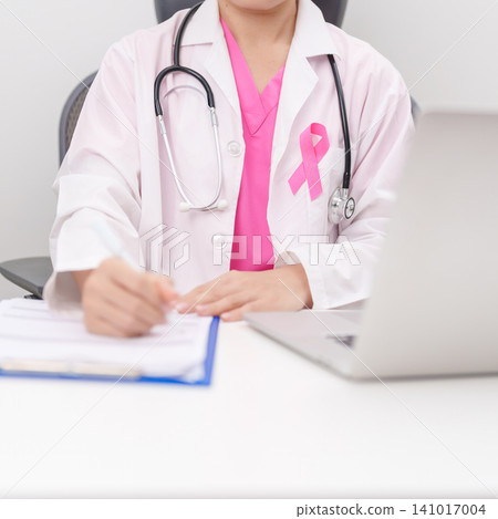 Professional doctor wearing lab coat using laptop and taking report notes on notebook for Breast Cancer Awareness month, World Cancer Day, National Cancer Survivors Month and Pink October in hospital Professional doctor wearing lab coat using laptop and taking report notes on notebook for Breast Cancer Awareness month, World Cancer Day, National Cancer Survivors Month and Pink October in hospital 141017004