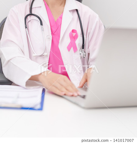 Professional doctor wearing lab coat using laptop and taking report notes on notebook for Breast Cancer Awareness month, World Cancer Day, National Cancer Survivors Month and Pink October in hospital Professional doctor wearing lab coat using laptop and taking report notes on notebook for Breast Cancer Awareness month, World Cancer Day, National Cancer Survivors Month and Pink October in hospital 141017007