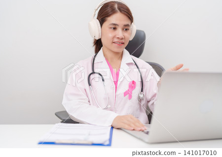 Professional doctor using laptop for telehealth, telemedical, online consultation and video meeting about Breast Cancer Awareness month, World Cancer Day and Pink October in hospital office concept Professional doctor using laptop for telehealth, telemedical, online consultation and video meeting about Breast Cancer Awareness month, World Cancer Day and Pink October in hospital office concept 141017010