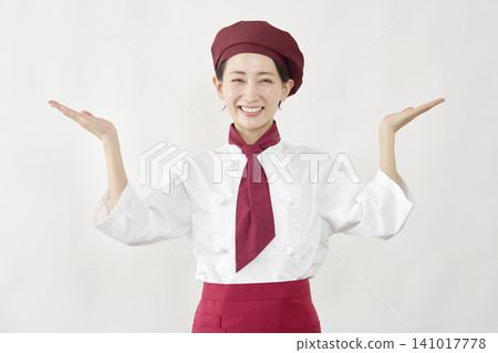 A female pastry chef points to the left and right with her palms. 141017778