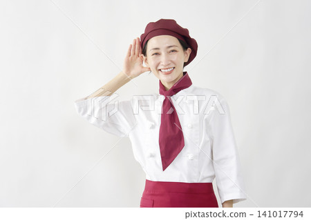 Female pastry chef/baker/cafe employee, in a listening pose, against a white background. Female pastry chef/baker/cafe employee, in a listening pose, against a white background. 141017794