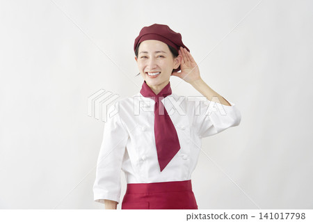 Female pastry chef/baker/cafe employee, in a listening pose, against a white background. Female pastry chef/baker/cafe employee, in a listening pose, against a white background. 141017798