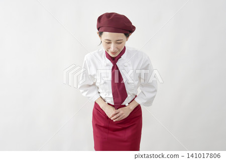 Female pastry chef/baker/cafe employee bowing against a white background. Female pastry chef/baker/cafe employee bowing against a white background. 141017806