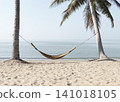 A bamboo hammock hangs under a coconut tree on the beach by the sea. 141018105