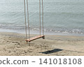 A wooden hanging swing on the beach by the sea. 141018108
