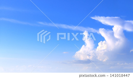 White clouds in the blue sky. Beautiful nature landscape. The azure expanse of the sky is adorned with pristine white clouds, creating a picturesque natural scene White clouds in the blue sky. Beautiful nature landscape. The azure expanse of the sky is adorned with pristine white clouds, creating a picturesque natural scene 141018447
