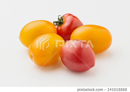 Yellow and red cherry tomatoes arranged together against a white background. Yellow and red cherry tomatoes arranged together against a white background. 141018888