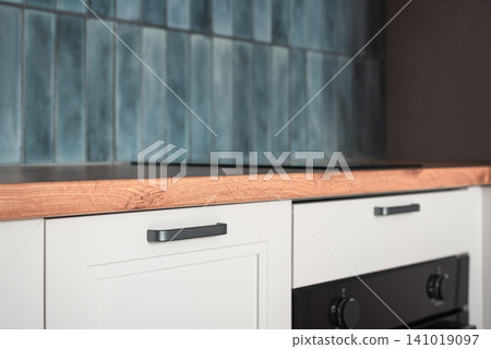Modern kitchen countertop with blue ceramic tile backsplash and white cabinets Modern kitchen countertop with blue ceramic tile backsplash and white cabinets 141019097
