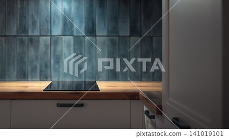Modern kitchen countertop with induction cooktop and blue ceramic tile backsplash Modern kitchen countertop with induction cooktop and blue ceramic tile backsplash 141019101