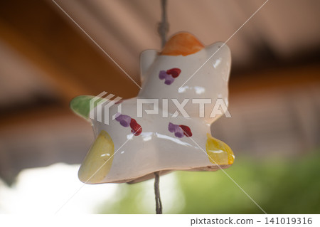 Ceramic bear ornament hanging indoors with colorful painted spots and soft blur background Ceramic bear ornament hanging indoors with colorful painted spots and soft blur background 141019316