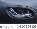 Car door handle chrome handle black panel interior detail vehicle part close up shiny metal black plastic modern design silver trim 141019386