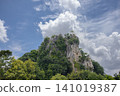 Limestone mountain tropical forest blue sky cloud rocky cliff green tree natural landscape sunny day dramatic sky jungle view 141019387