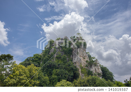Limestone mountain tropical forest blue sky cloud rocky cliff green tree natural landscape sunny day dramatic sky jungle view Limestone mountain tropical forest blue sky cloud rocky cliff green tree natural landscape sunny day dramatic sky jungle view 141019387