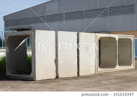 Concrete box culvert segments on industrial site, large precast concrete structure outdoors near warehouse wall Concrete box culvert segments on industrial site, large precast concrete structure outdoors near warehouse wall 141019397